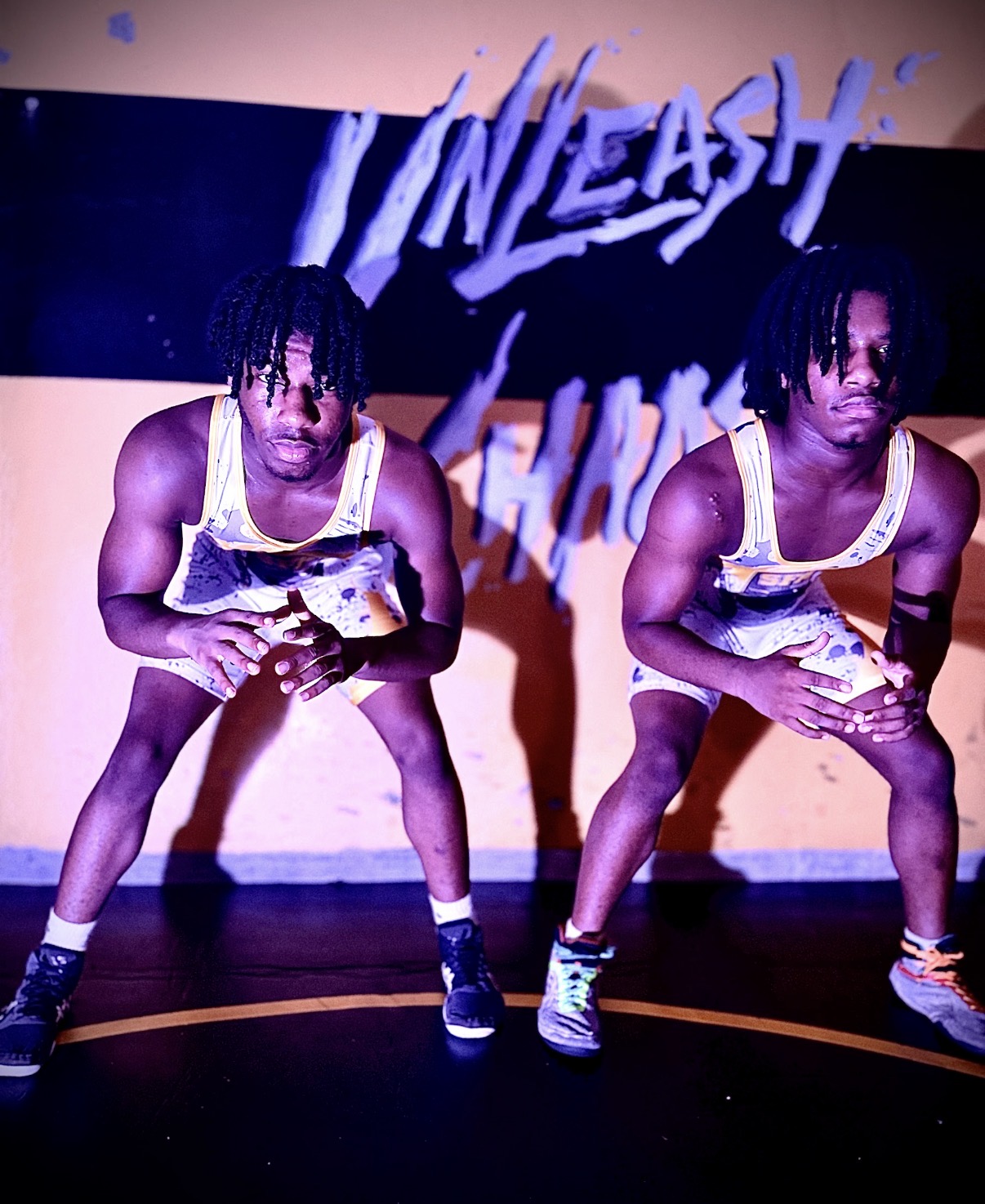 Two St. Francis wrestlers ready to train beneath the Unleash Chaos wall